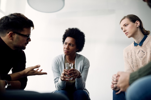 Grupo de pessoas conversando entre si durante a reunião de terapia