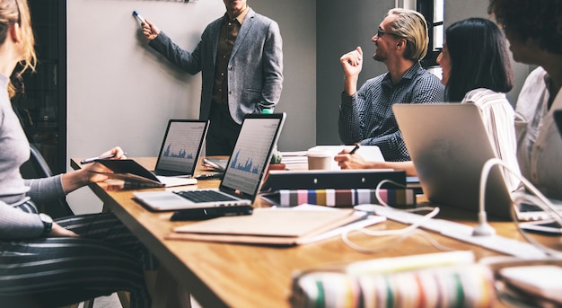 Grupo de pessoas diversas, tendo uma reunião de negócios