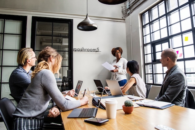 Grupo de pessoas diversas, tendo uma reunião de negócios