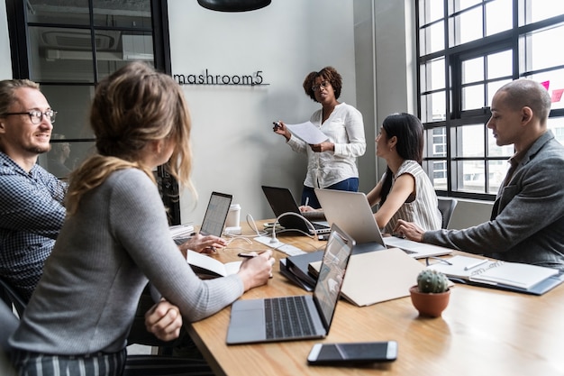 Grupo de pessoas diversas, tendo uma reunião de negócios