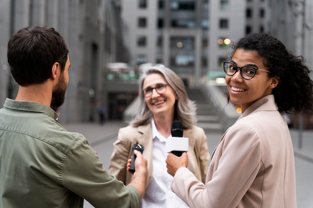 Grupo de pessoas fazendo uma entrevista de jornalismo