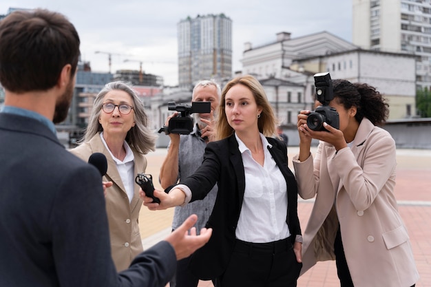 Grupo de pessoas fazendo uma entrevista para o noticiário