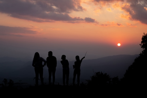 Grupo de pessoas felizes brincando no pôr do sol de verão na natureza