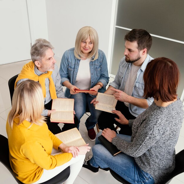 Grupo de pessoas lendo livros em sessão de terapia