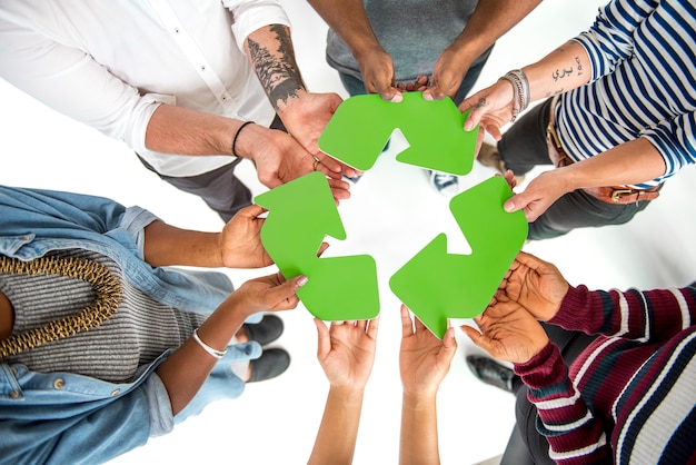 Foto grátis grupo de pessoas segurando o conceito de placa de reciclagem