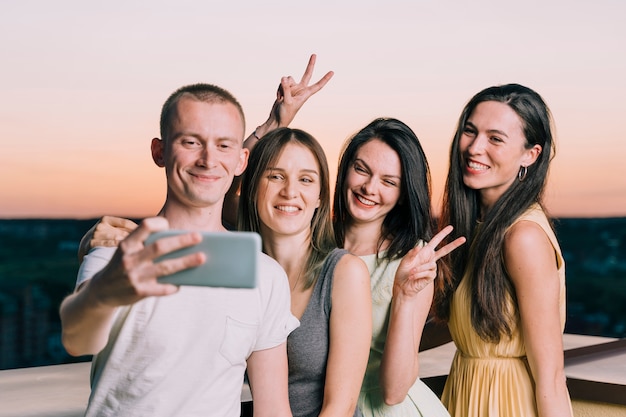 Grupo de pessoas tomando selfie na festa no terraço
