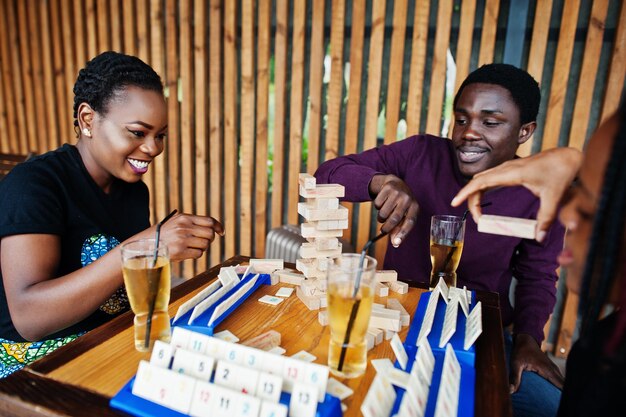 Grupo de três amigos afro-americanos jogam jogos de mesa