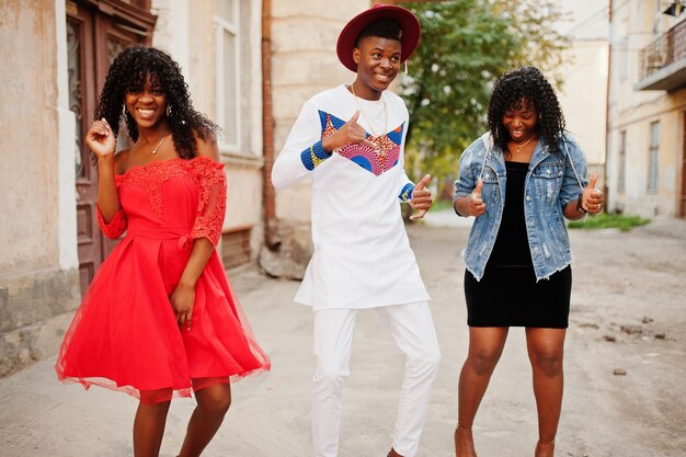 Grupo de três amigos elegantes da afro-francesa posaram no dia do outono Modelo de homem negro africano com duas mulheres de pele escura