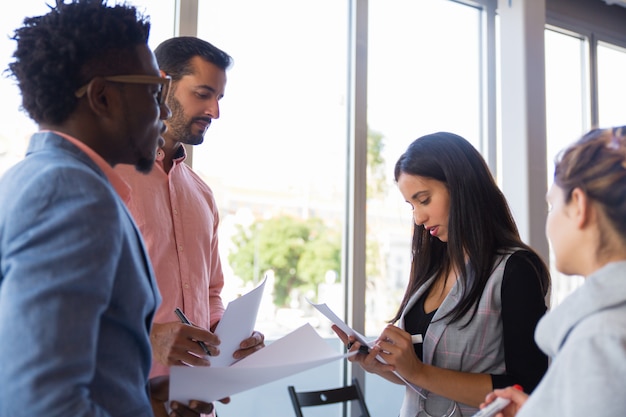 Grupo diversificado de colegas tomando notas