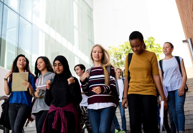 Grupo diverso de estudantes caminhando na escola