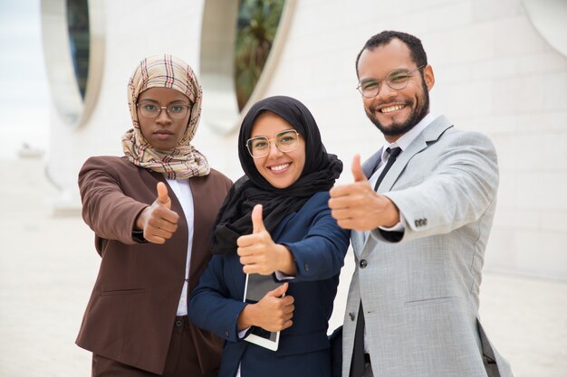 Grupo empresarial multicultural posando e fazendo como gesto