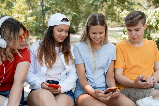 Grupo médio de amigos olhando para o telefone