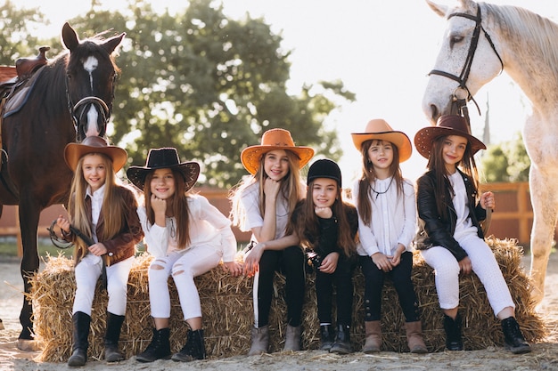 Foto grátis grupo meninas, sentando, ligado, feno, com, cavalos