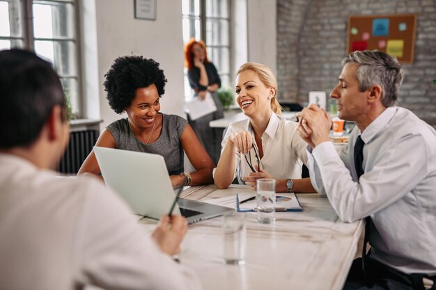 Grupo multiétnico de empresários felizes tendo uma reunião no escritório moderno