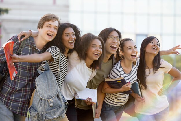 Grupo multiétnico de jovens estudantes felizes em pé ao ar livre