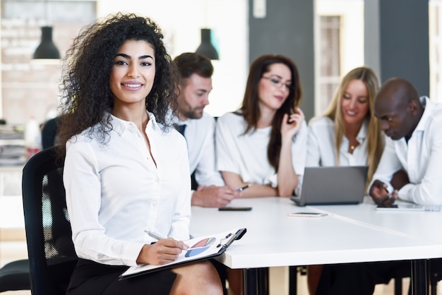 Grupo multiétnico de três empresários reunidos em um moderno o