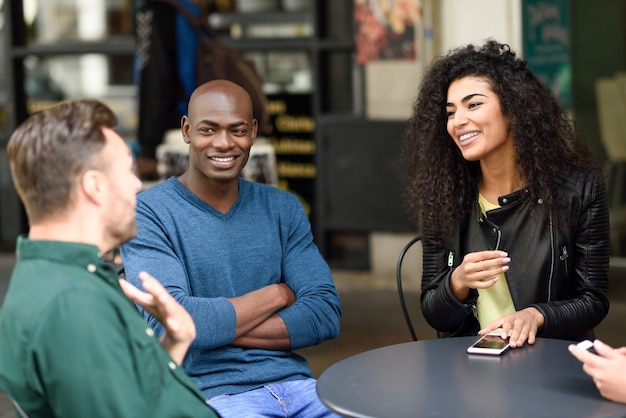 Grupo multirracial de amigos esperando por um café juntos