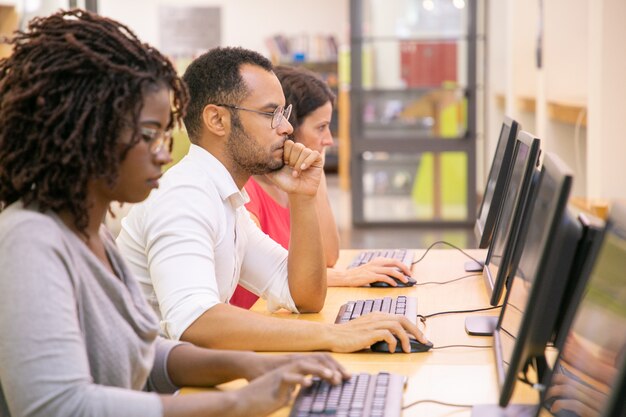 Grupo multirracial de estudantes a treinar em aula de informática