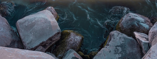 Água azul do oceano encontrando-se com as pedras da praia. Foto de alta qualidade