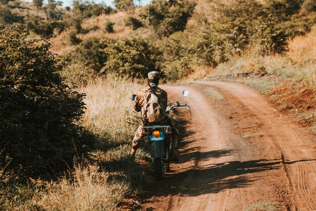 Guarda anti-caça furtiva em uma motocicleta, em uma estrada de terra