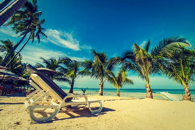 Guarda-chuva e cadeira em torno da praia e do mar para viagens e férias