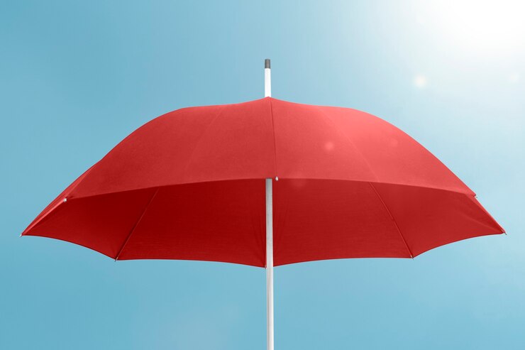Foto grátis guarda-chuva vermelho com espaço de cópia no céu azul