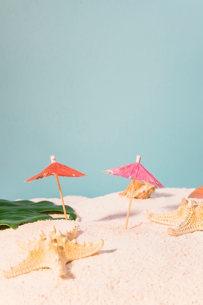 Foto grátis guarda-chuvas de cocktail e estrela do mar na praia