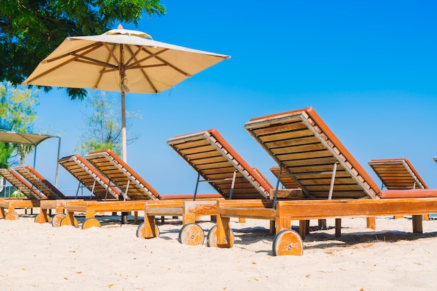 Guarda-sol piscina e cadeira na praia