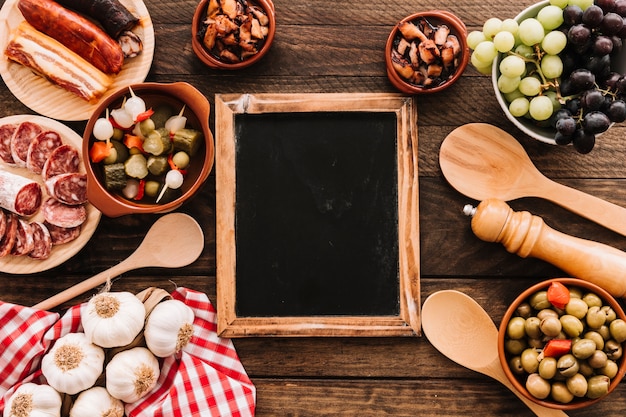 Guardanapo e colheres perto de comida e lousa