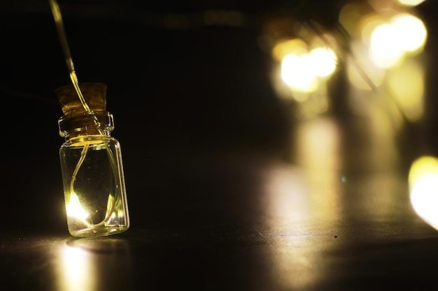 Guirlanda de natal de garrafas de vidro, potes com uma planta dentro. conceito de ano novo e natal. uma guirlanda de lâmpadas com uma bela luz e bokeh Foto Premium