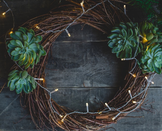 Guirlanda de porta de natal feita de galhos e suculentus.