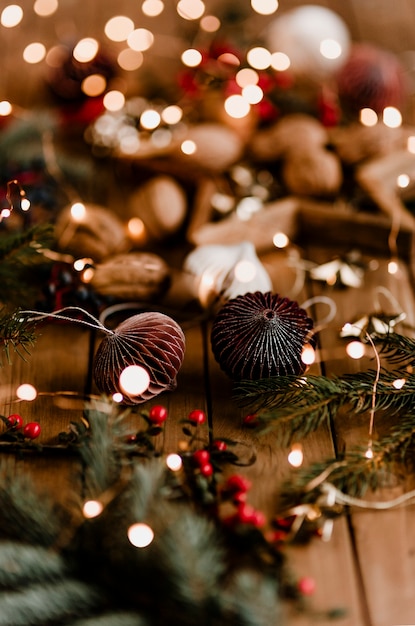 Guirlandas de bolas de papel com luzes de natal em uma mesa de madeira