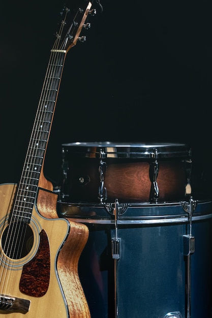 Guitarra acústica e tarola em um fundo preto isolado