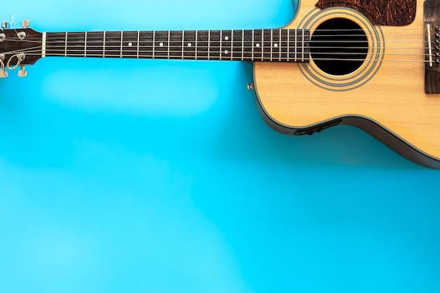 Guitarra acústica em um plano de fundo azul, vista superior, cópia espaço