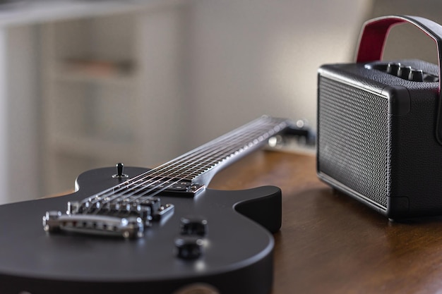 Foto grátis guitarra elétrica preta e alto-falante em uma mesa de madeira