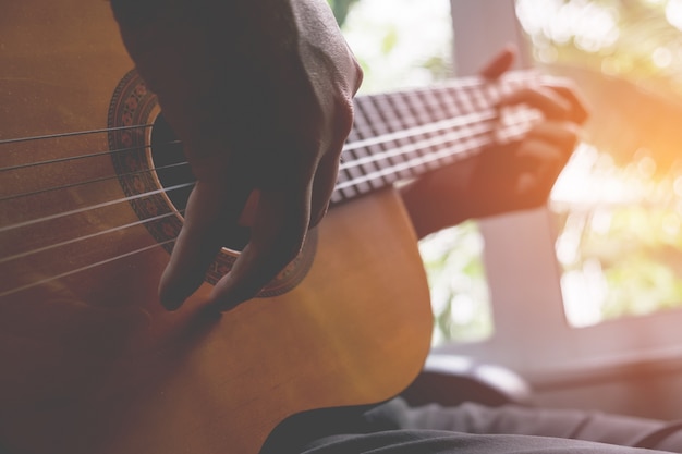 Guitarrista de guitarra acústica brincando. instrumento musical com mãos de artista.