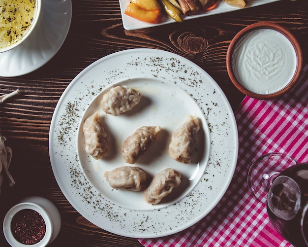 Gyurza em um prato branco com sumagre e creme de leite