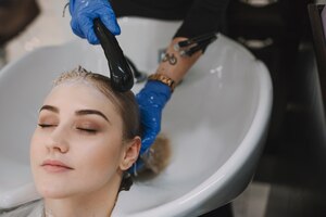 Foto grátis hairstylist lavando o cabelo do cliente na pia