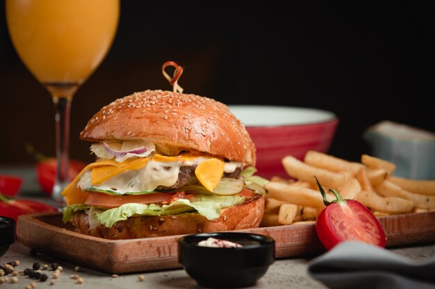 Hambúrguer com batatas fritas e suco de laranja.