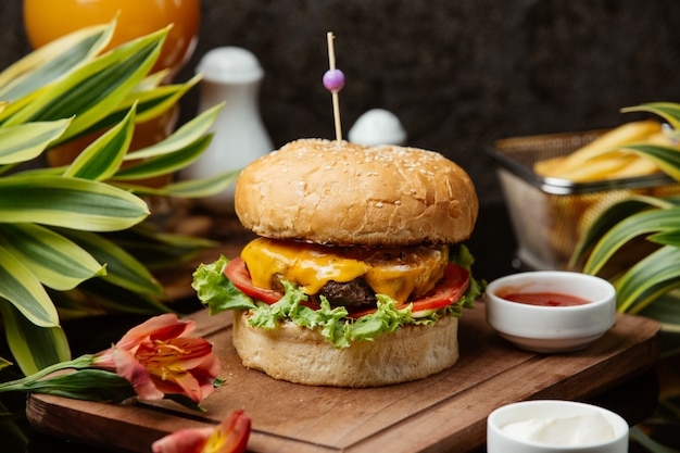 Hambúrguer de carne com alface, queijo cheddar derretido, tomate, maionese e ketchup