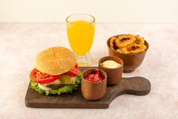 Hambúrguer de carne com queijo e salada verde junto com ketchup e mostarda na mesa de madeira