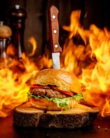 Foto grátis hambúrguer de carne de fogo em um cânhamo de madeira