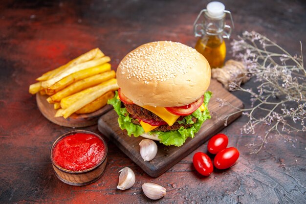 Hambúrguer de carne de frente com salada de queijo e tomate no fundo escuro