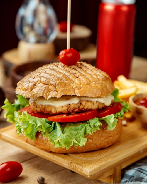 Foto grátis hambúrguer de frango com tomate em pão crocante