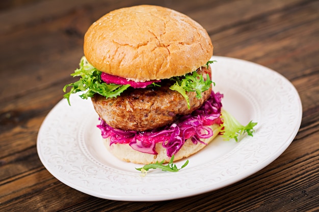 Hambúrguer de sanduíche com hambúrgueres suculentos, repolho roxo e molho rosa