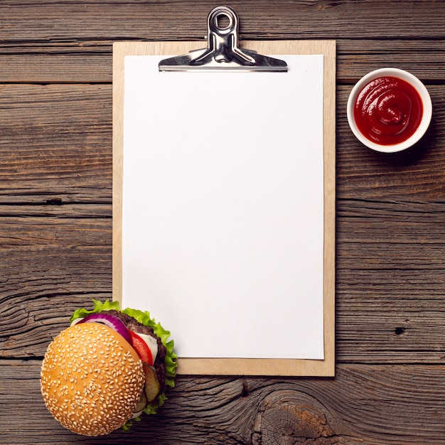 Foto grátis hambúrguer de vista superior com prancheta de mock-up