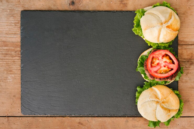 Foto grátis hamburguer flat-lay em ardósia com copyspace