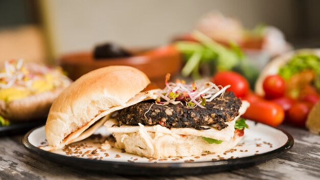 Hambúrguer vegetariano de quinoa com brotos e sementes de linho na chapa branca