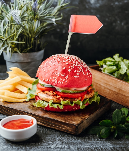 Hambúrguer vermelho com batatas fritas em cima da mesa