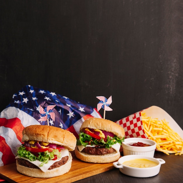 Hambúrgueres, bandeira americana e batatas fritas